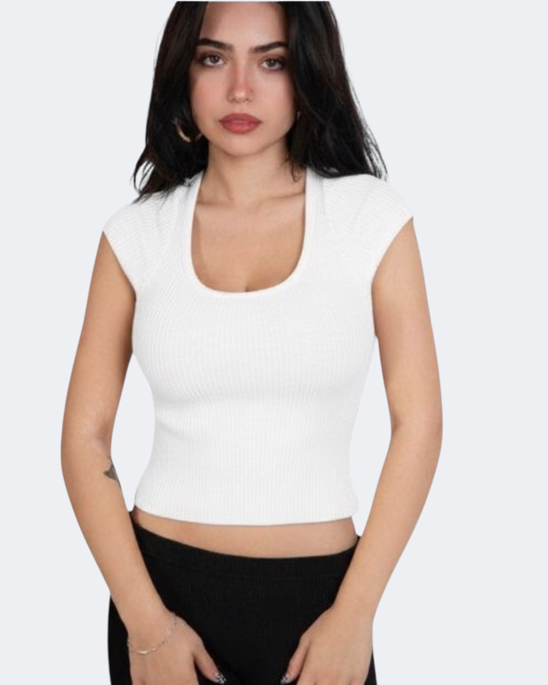 girl wearing s white short sleeve scoop neck top with black bottom, standing against a plain white background