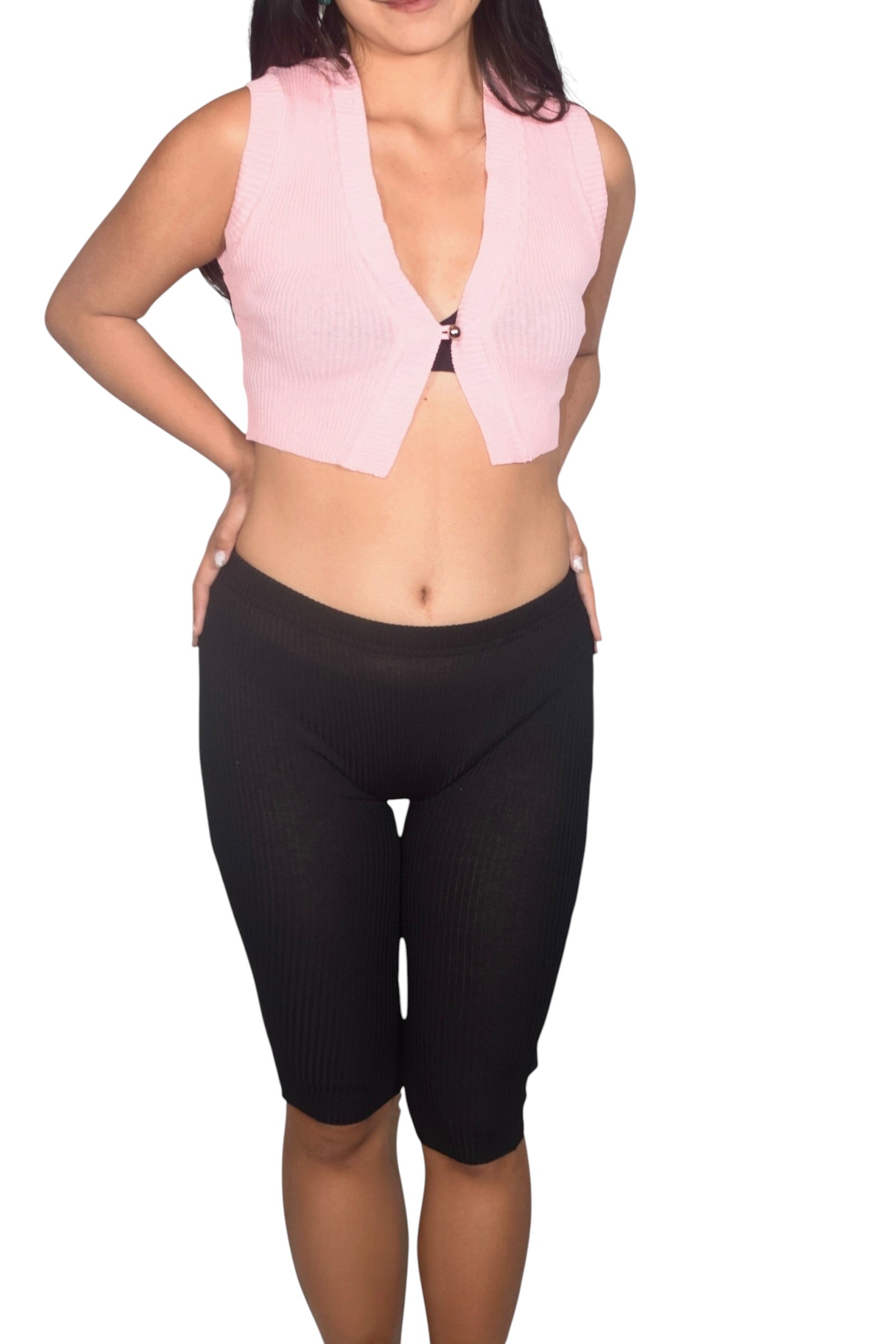 Person wearing a pink crop top and black capri pants on a white background