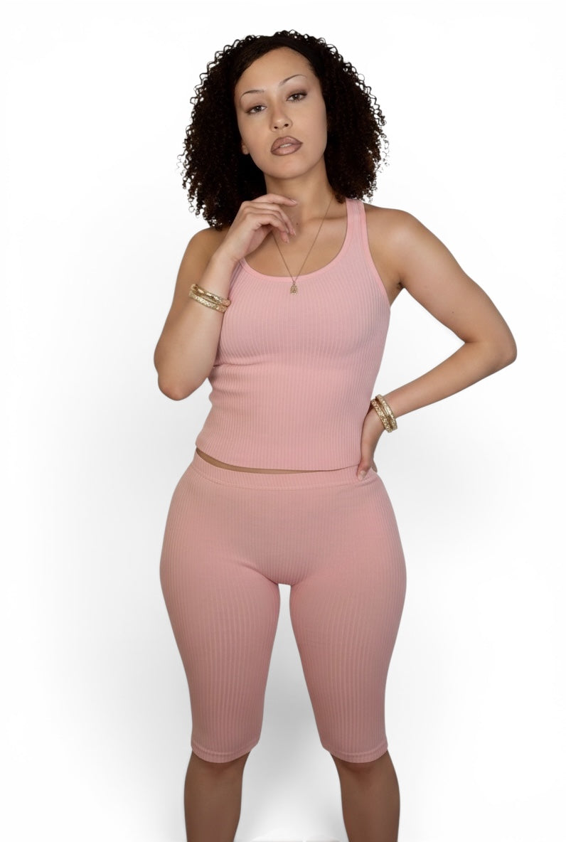Woman wearing a pink athletic outfit on a white background