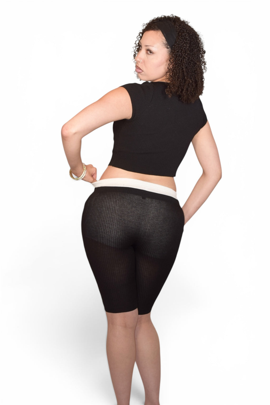 Person wearing black mesh shorts on a white background