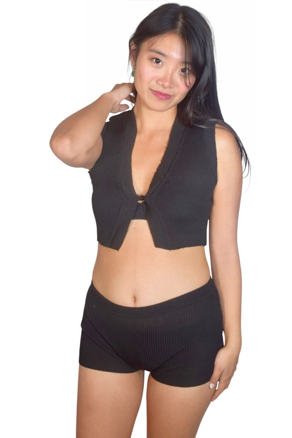 Woman wearing a black sleeveless top and shorts on a white background