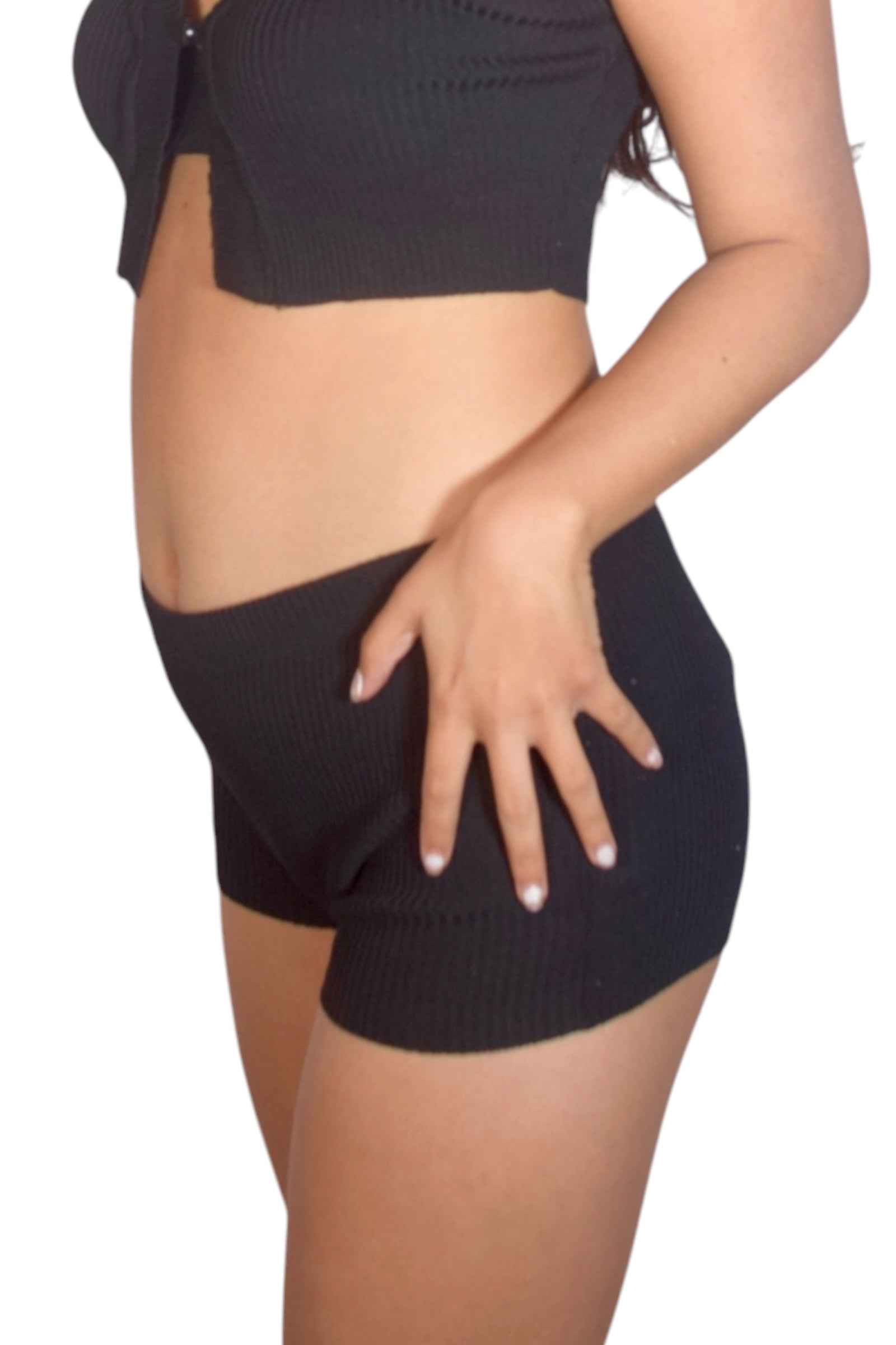 Person wearing black ribbed shorts on a white background