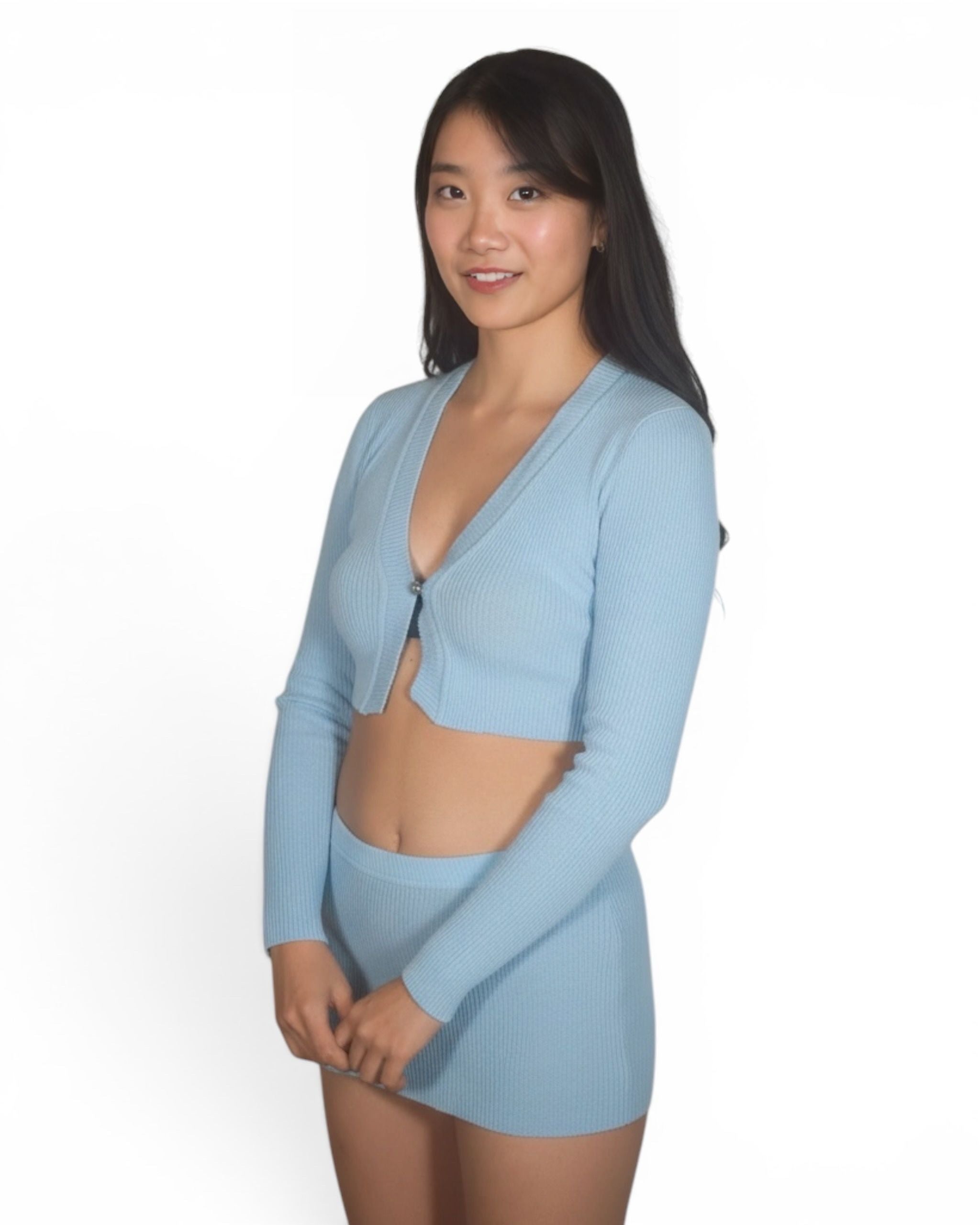 Woman wearing a light blue cardigan over a bikini on a white background
