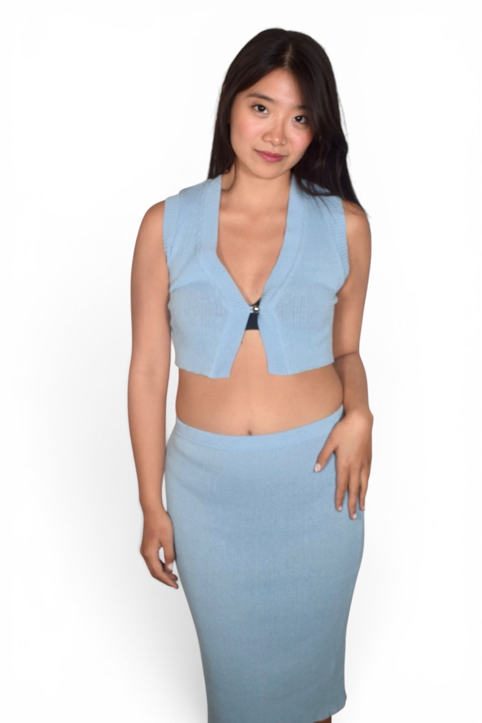 Woman wearing a light blue sleeveless top and skirt set on a white background