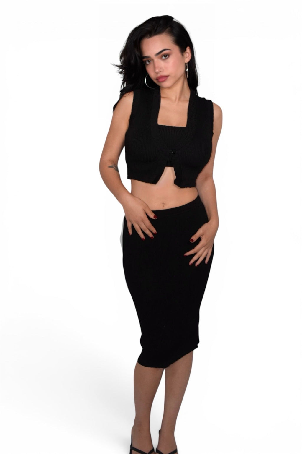 Woman wearing a black sleeveless top and skirt on a white background