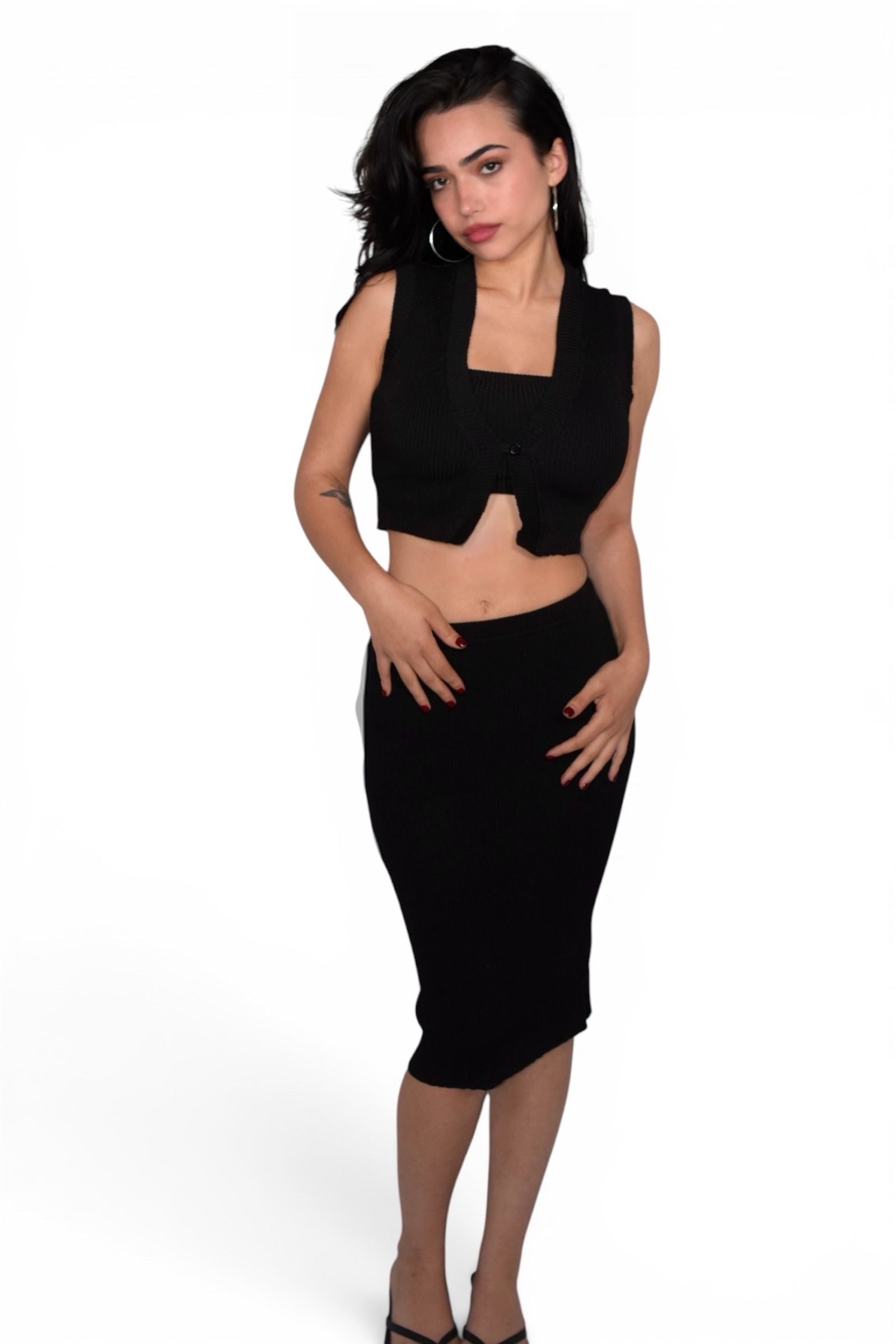 Woman wearing a black sleeveless top and skirt on a white background