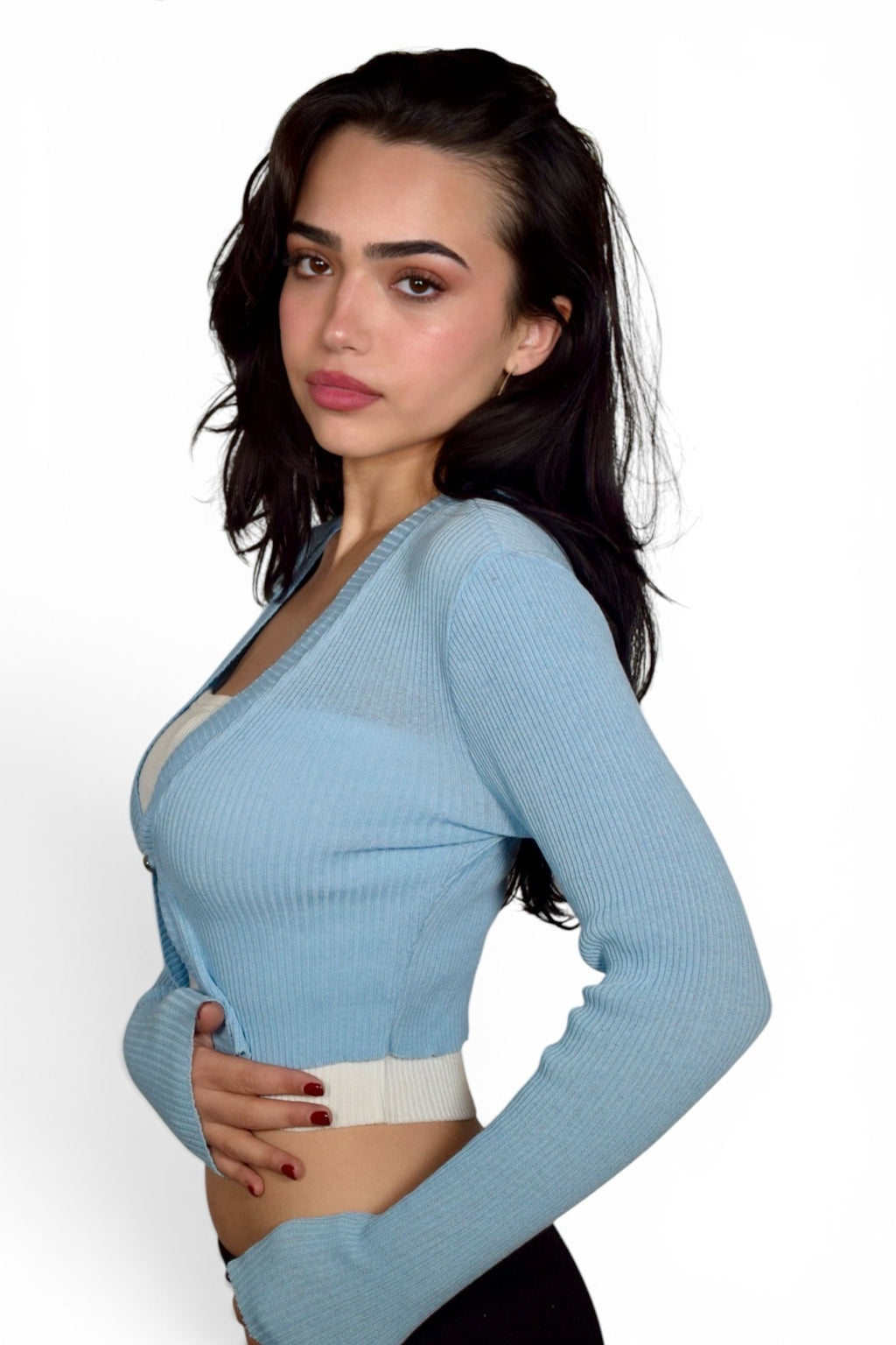 Woman wearing a light blue long-sleeve top on a white background
