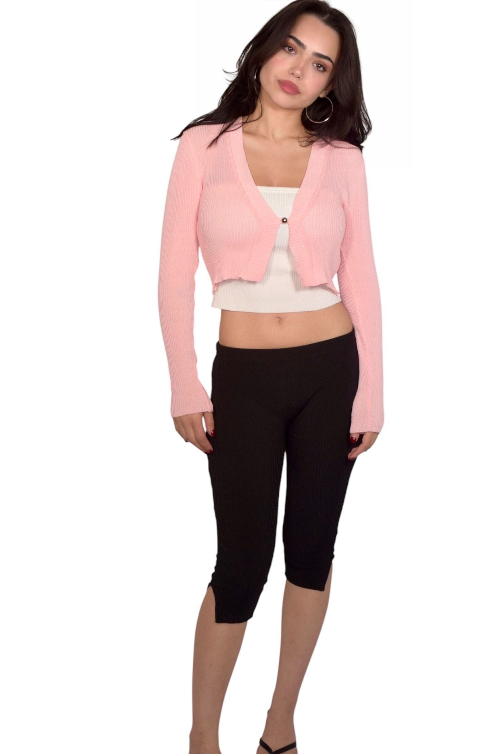 Woman wearing a pink single button shrug, white tube top, and black capris on a white background