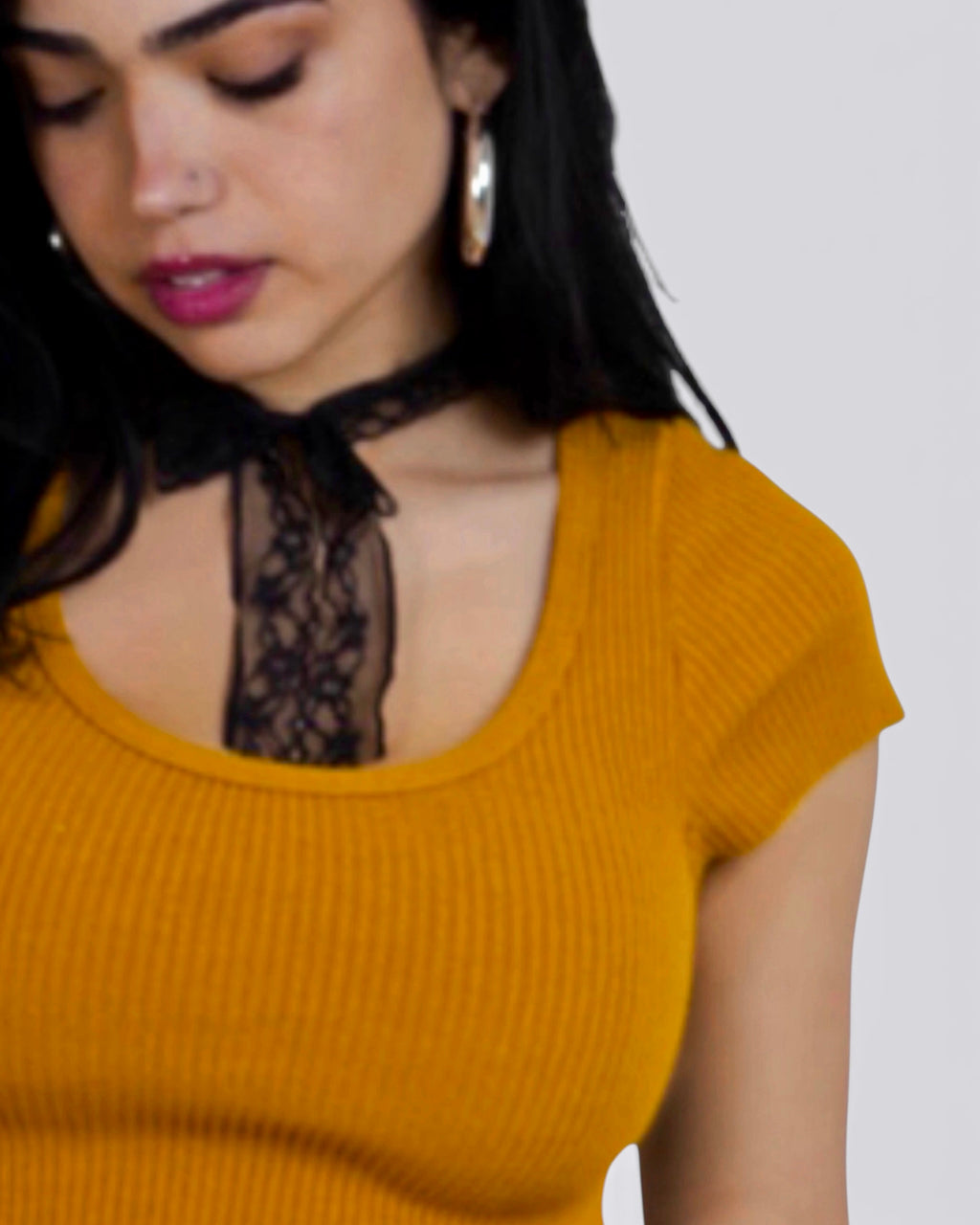 Woman wearing Dijon scoop neck short sleeve top w black lace necktie 
