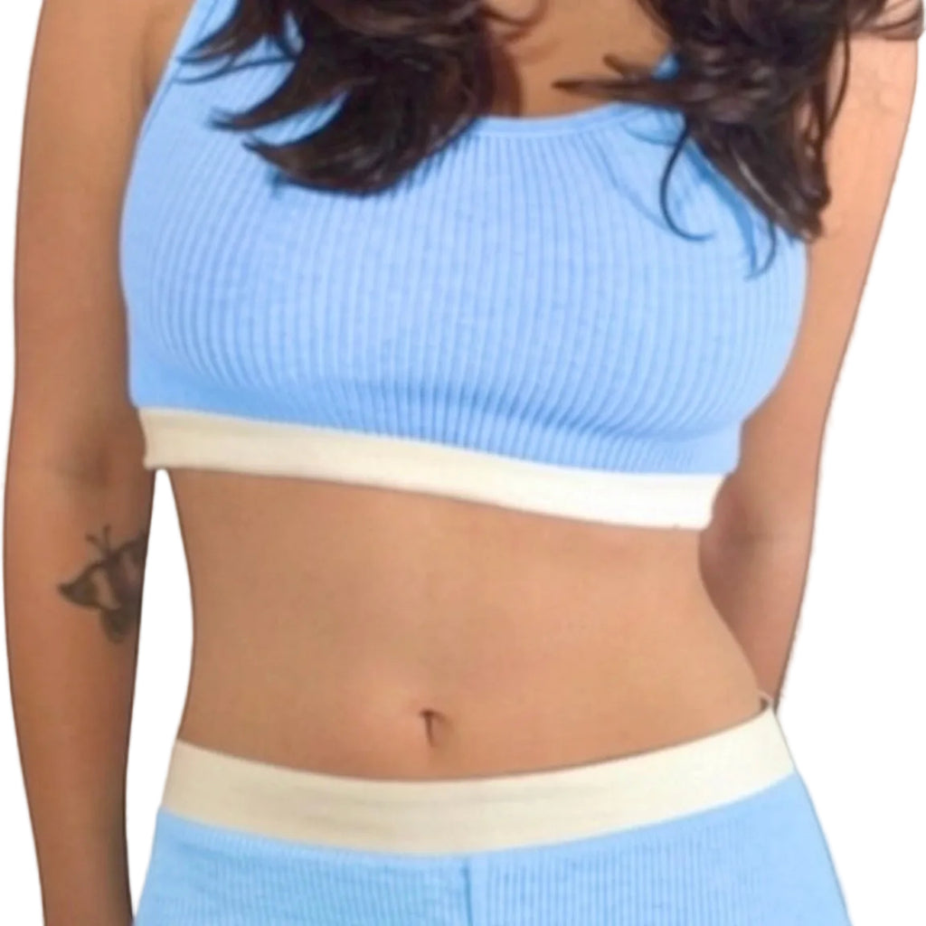 Person wearing a light blue and white two-piece outfit against a neutral background