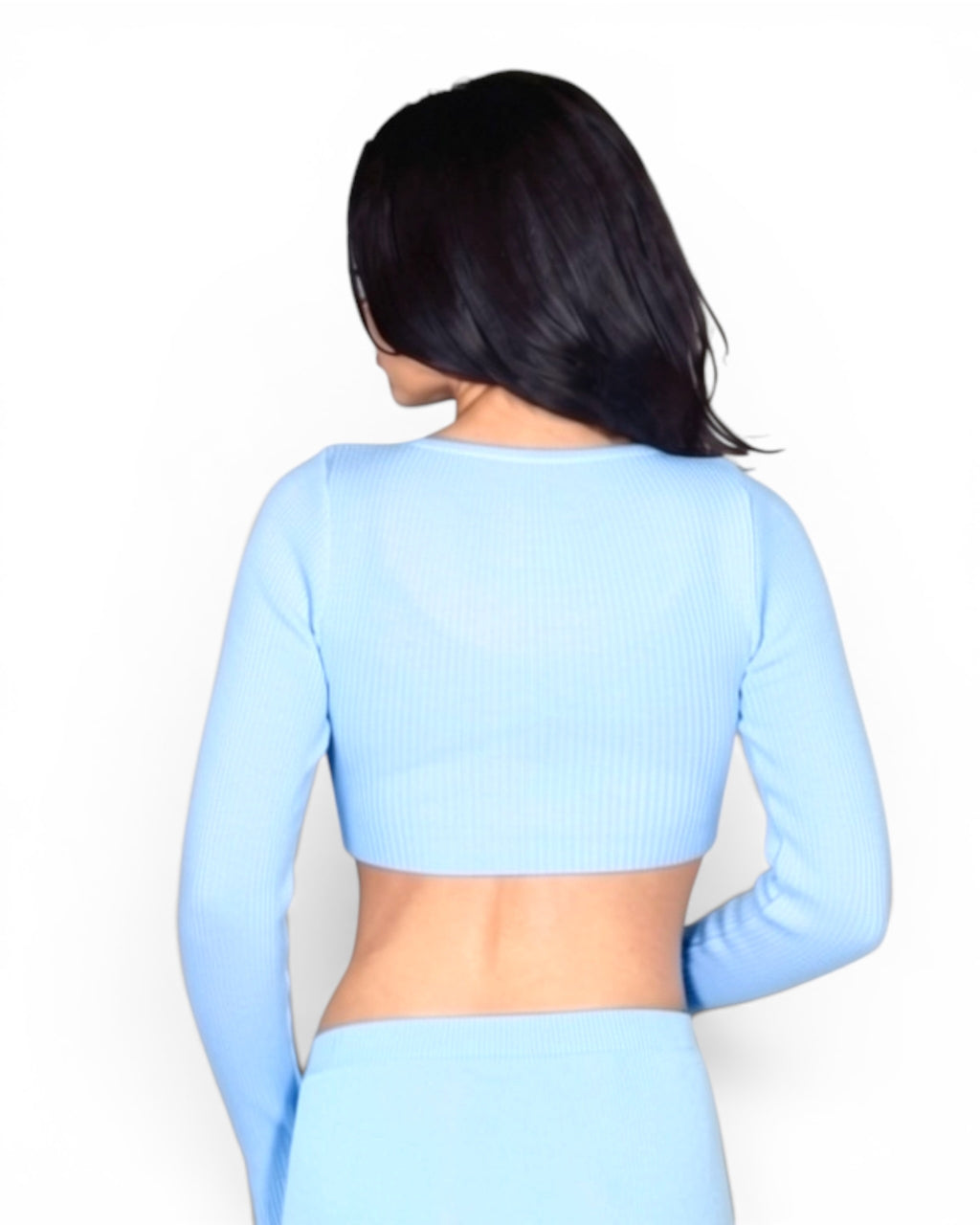 Person wearing a light blue long-sleeve crop top and pants on a white background