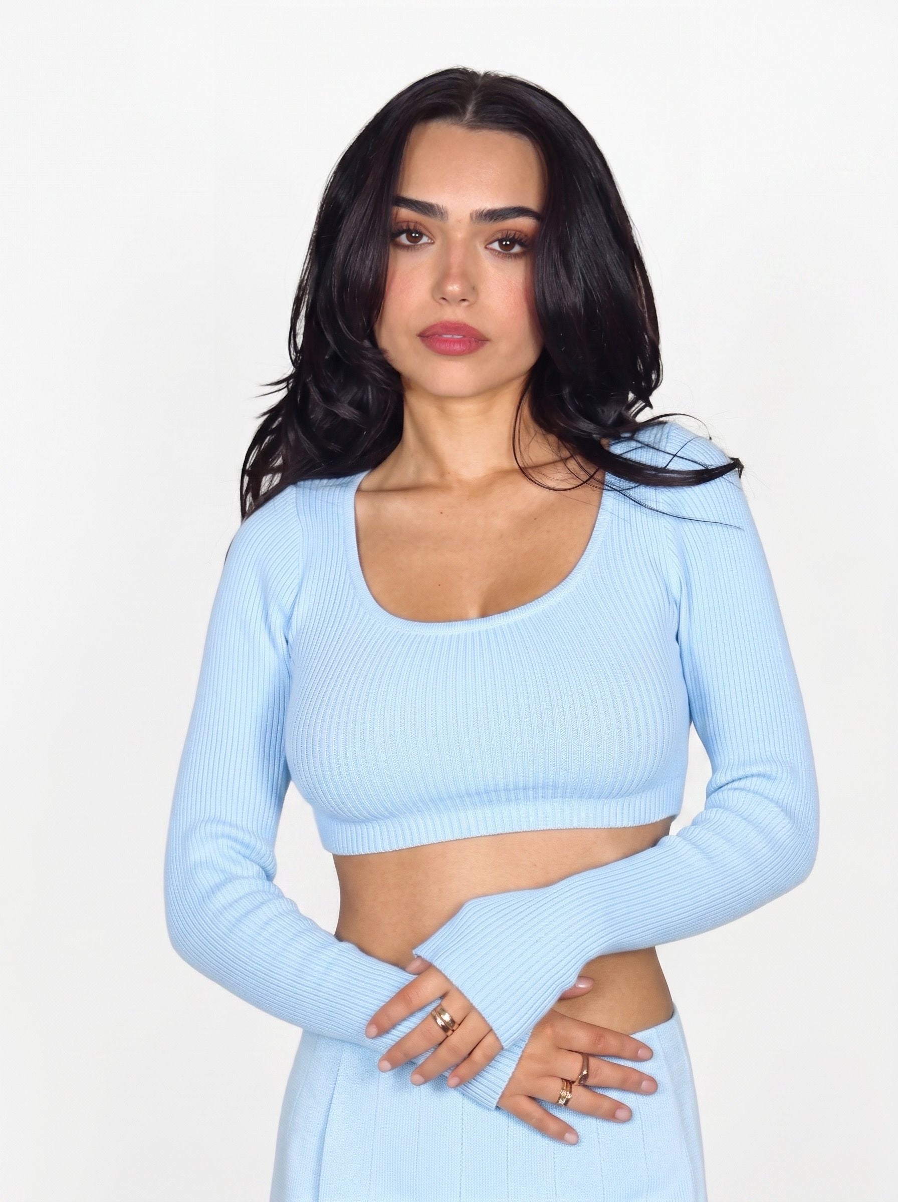 Woman wearing soft blue rib knit crop long sleeve scoop neck top by TKHLA