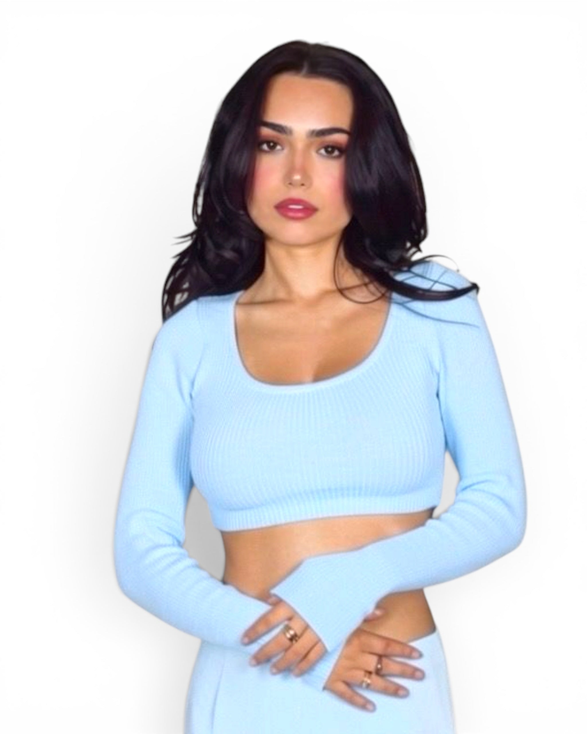 Woman wearing a light blue long-sleeve crop top against a white background