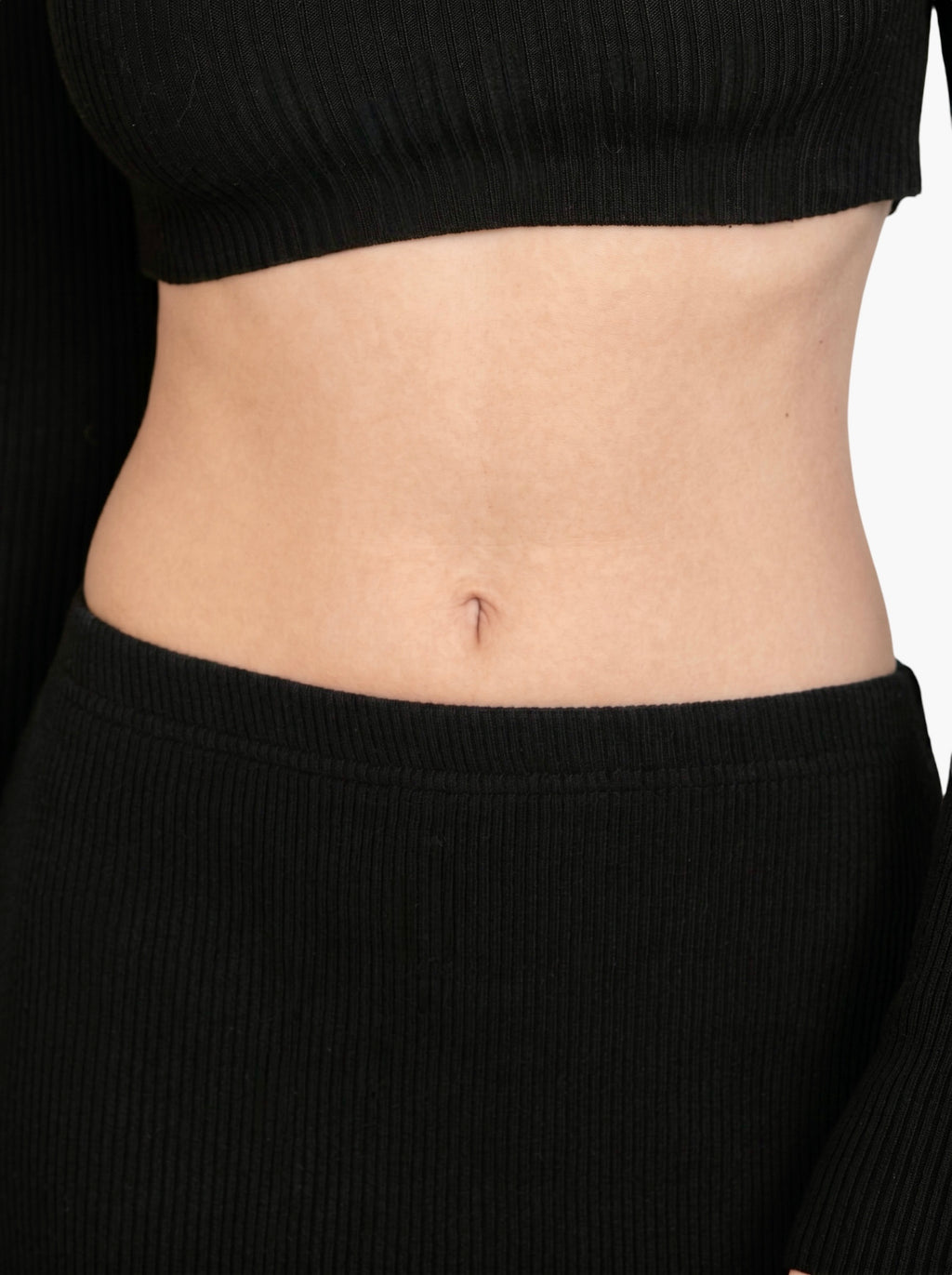 Close up of black rib knit top and bottom by TKHLA 