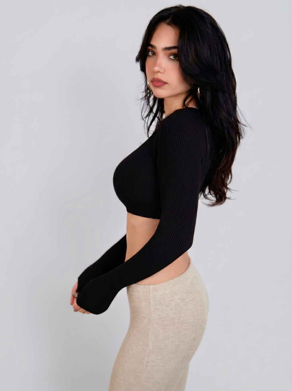 Woman wearing black rib knit crop long sleeve top and beige Capri by TKHLA 