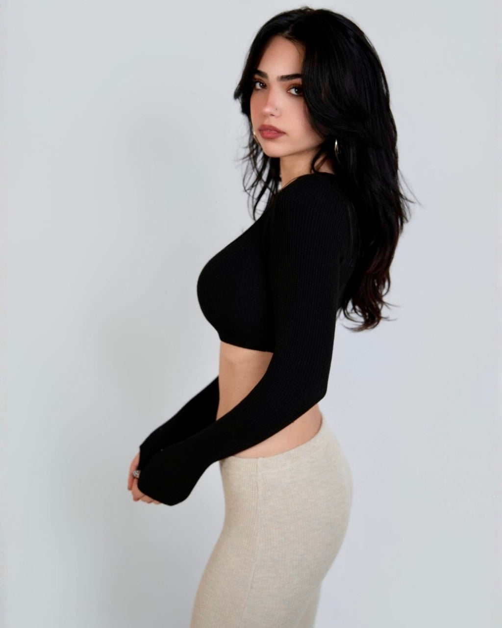 Woman wearing black crop long sleeve top and beige capri by The Knit House LA