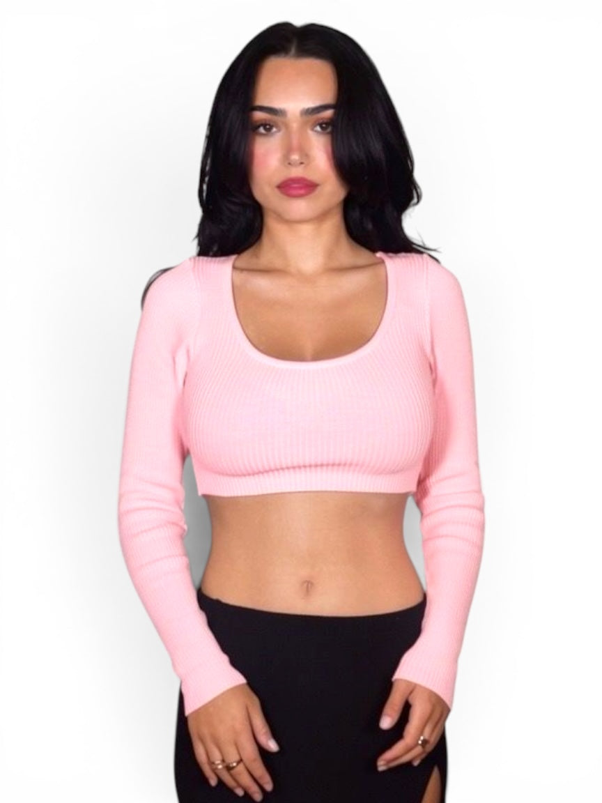 Woman wearing a pink long-sleeve crop top against a white background