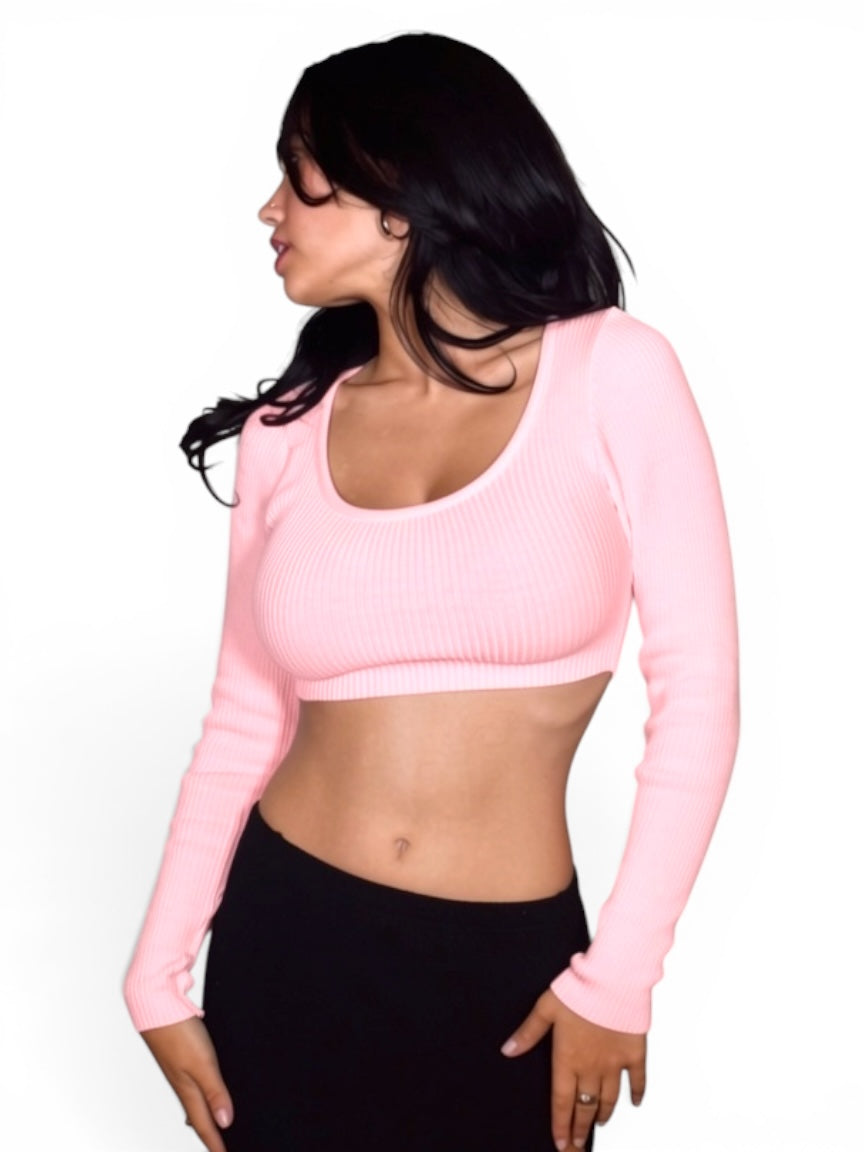 Woman wearing a pink long-sleeve crop top against a white background