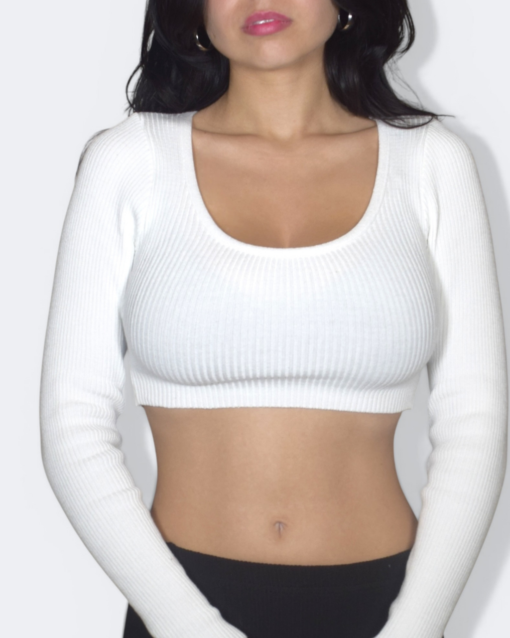 Person wearing a white ribbed scoop neck crop top against a plain background