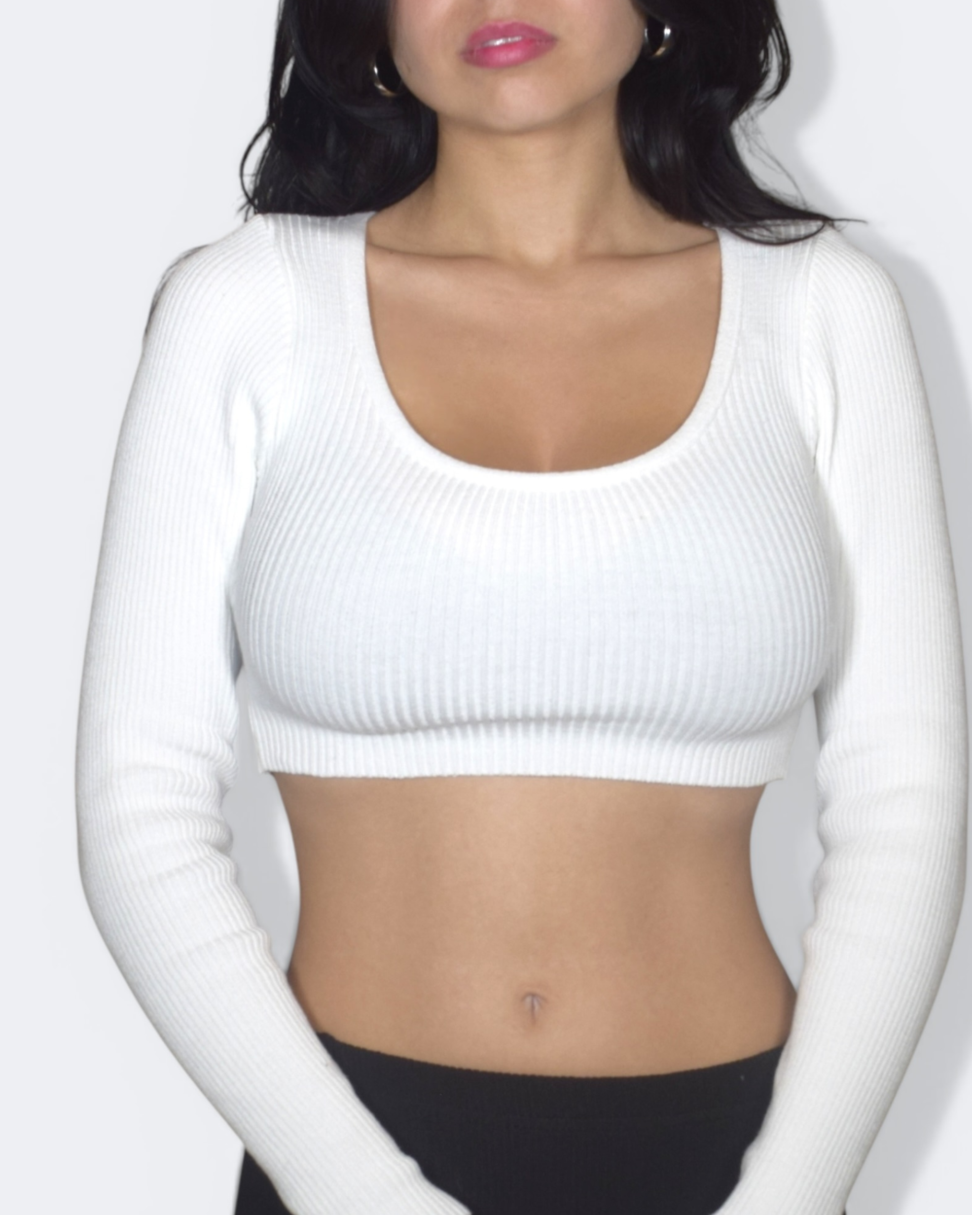 Person wearing a white ribbed scoop neck crop top against a plain background