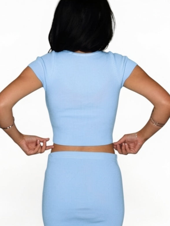 Light blue top and skirt worn by a person on a white background