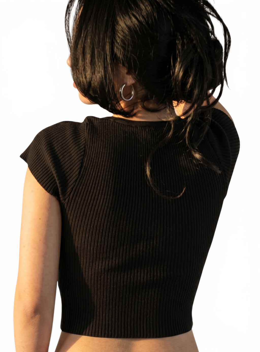 Back view of black knit crop short sleeve top by TKHLA 