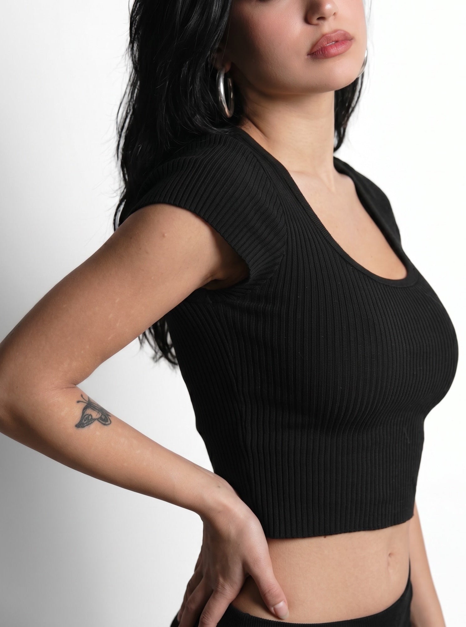 Woman wearing black rib knit crop short sleeve scoop neck top by TKHLA 