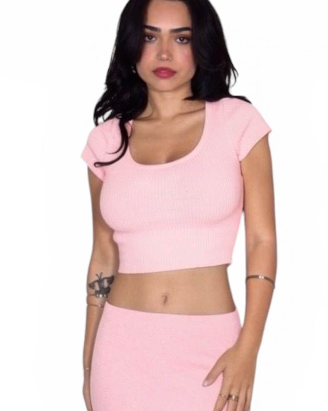 Woman wearing a pink crop top and skirt on a white background