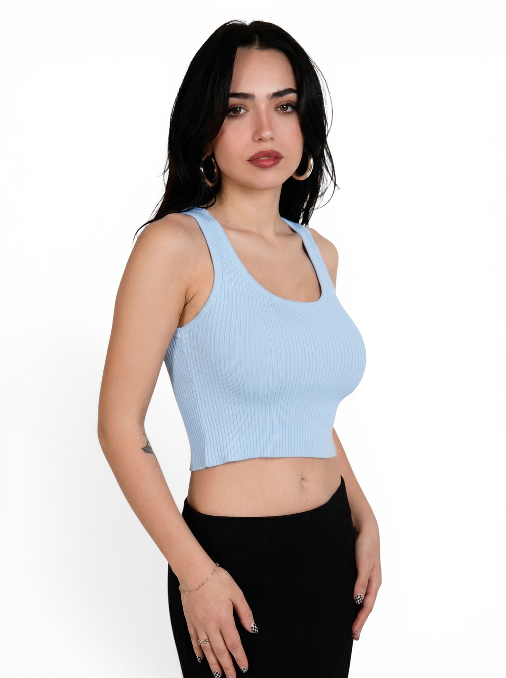 Woman wearing soft blue rib knit crop scoop neck tank and black skirt by TKHLA 