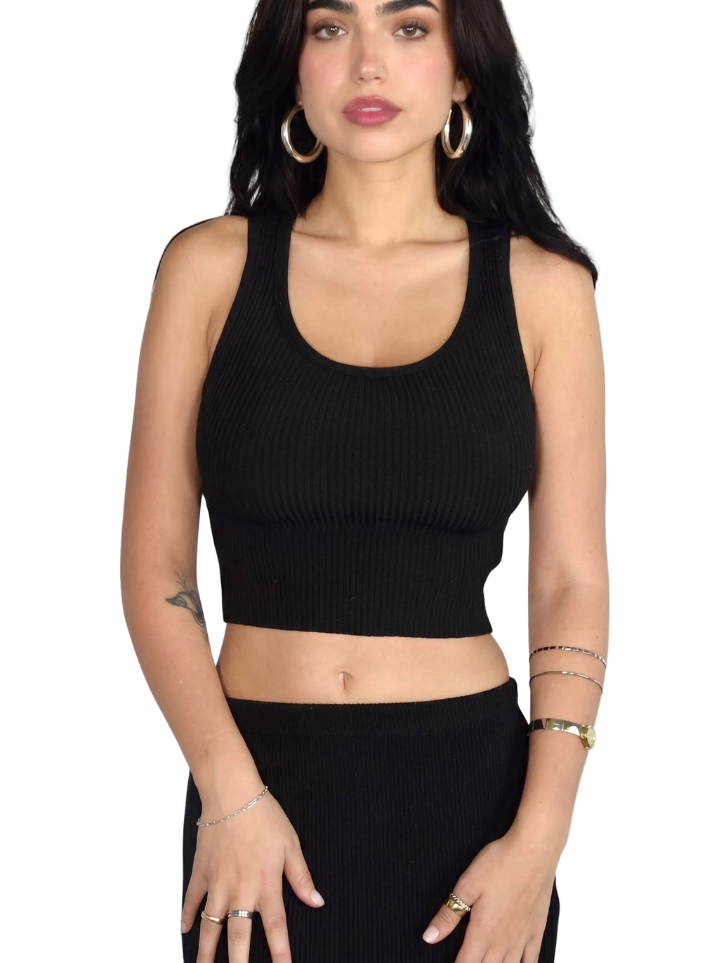 Woman wearing black rib knit scoop neck crop tank and skirt by TKHLA 