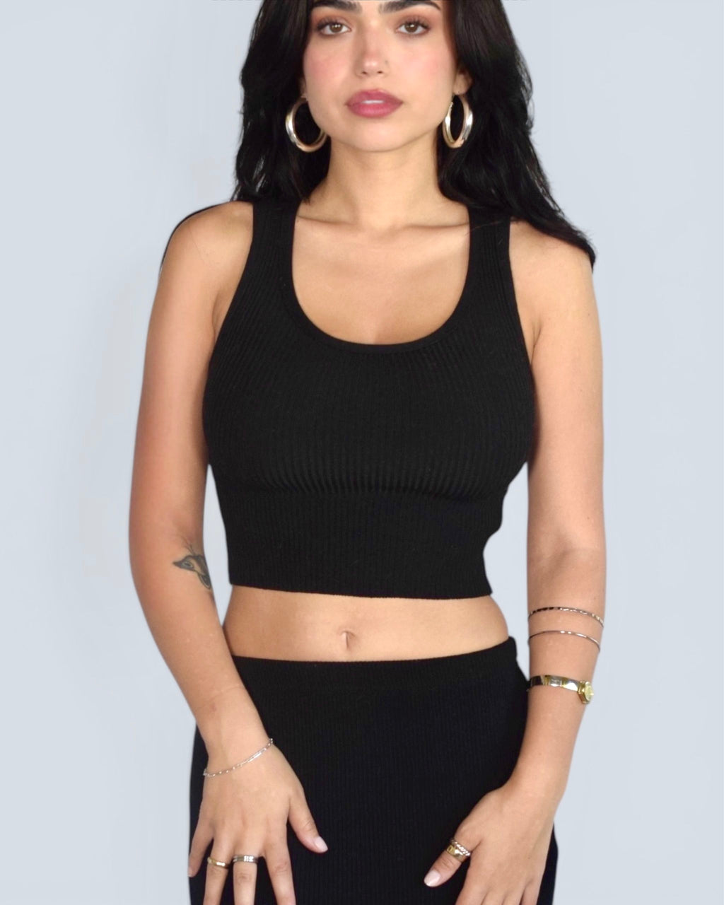 Woman wearing black scoop neck crop ribbed knit tank with black skirt by The Knit House LA