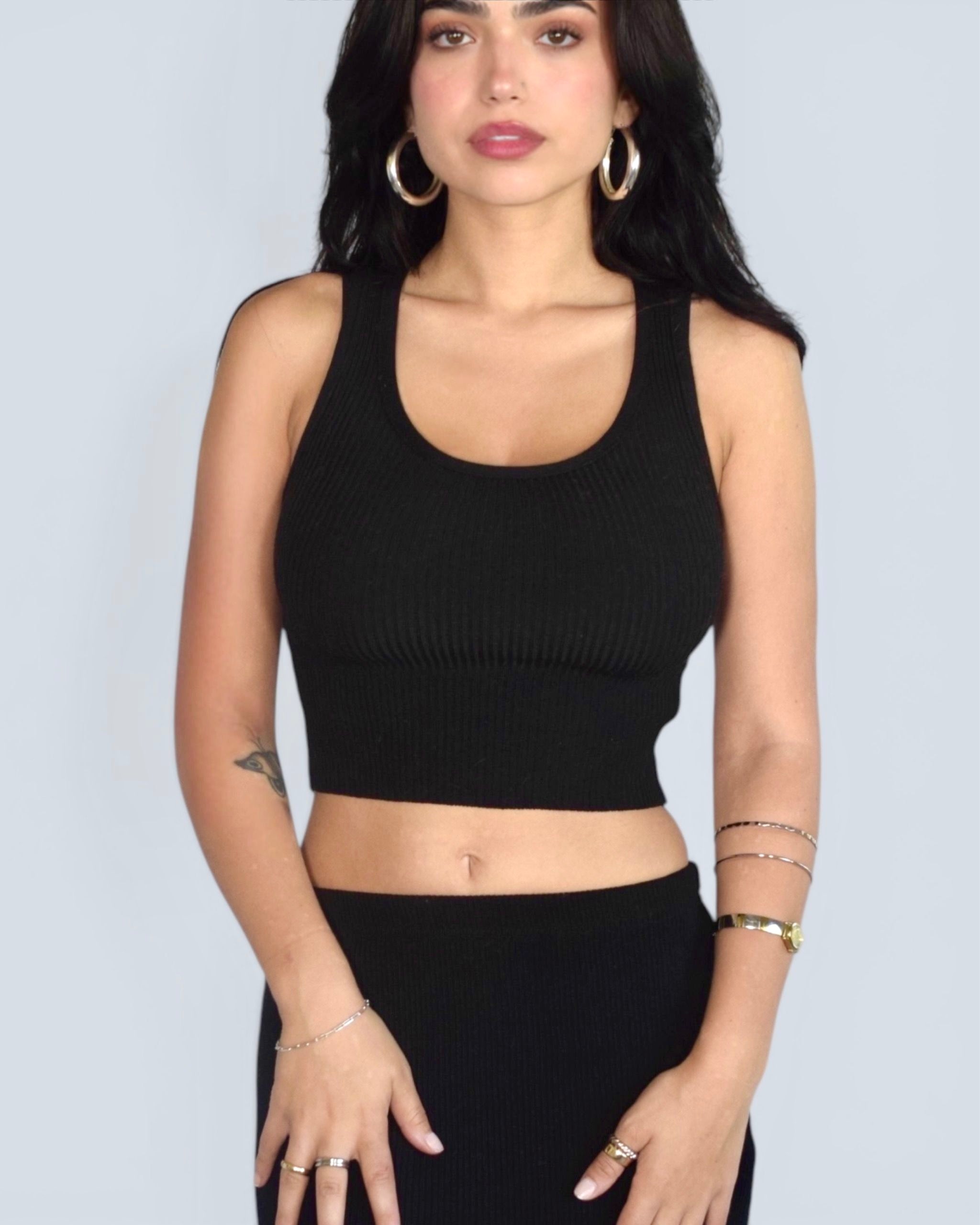 Woman wearing black scoop neck crop ribbed knit tank with black skirt by The Knit House LA