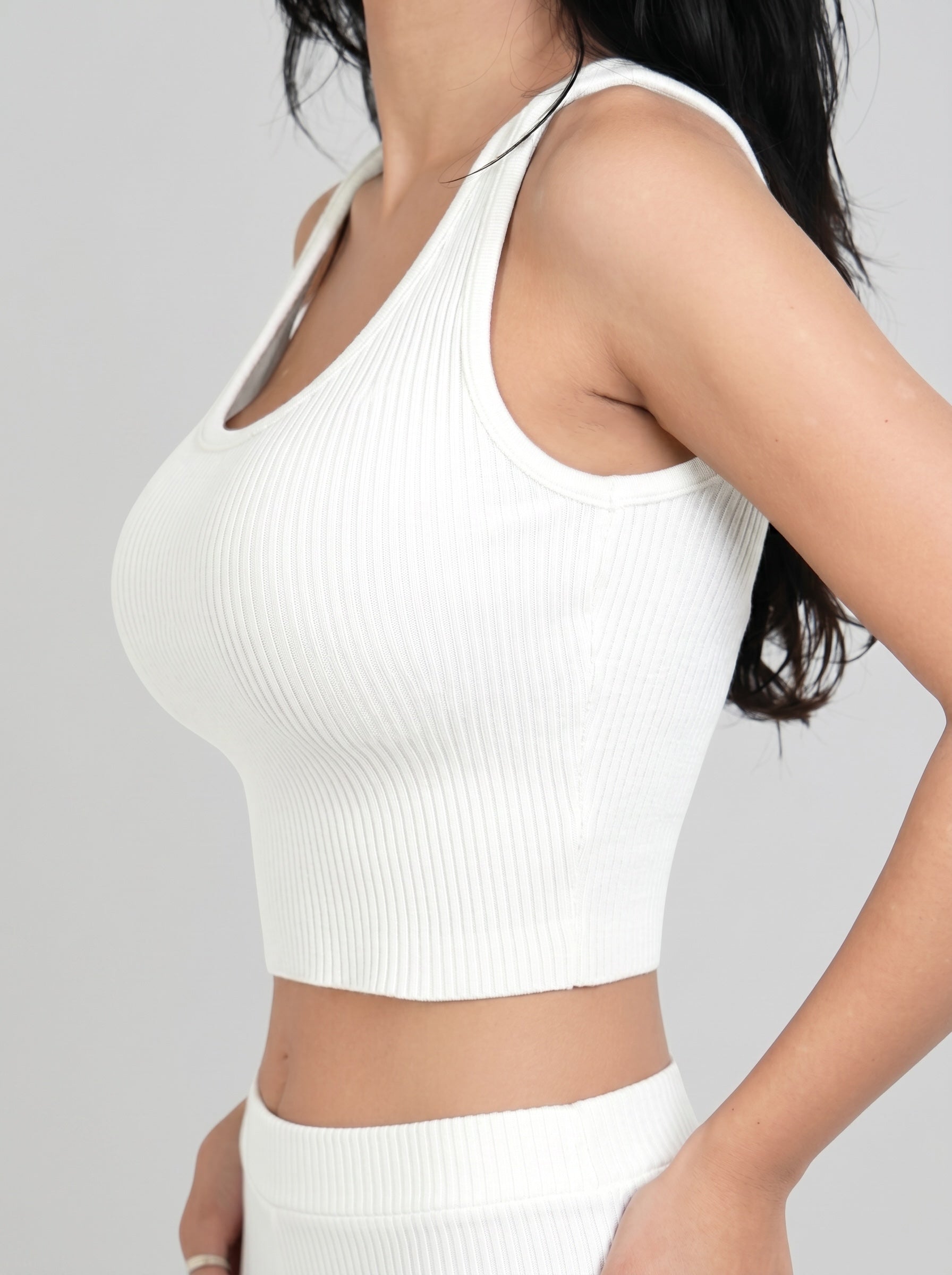 Side view of white rib knit scoop neck crop tank by TKHLA 