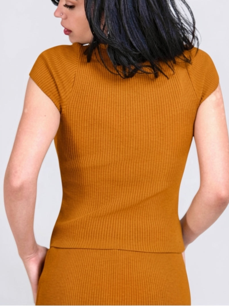 Back view of woman wearing short sleeve Dijon top and mini by TKHLA