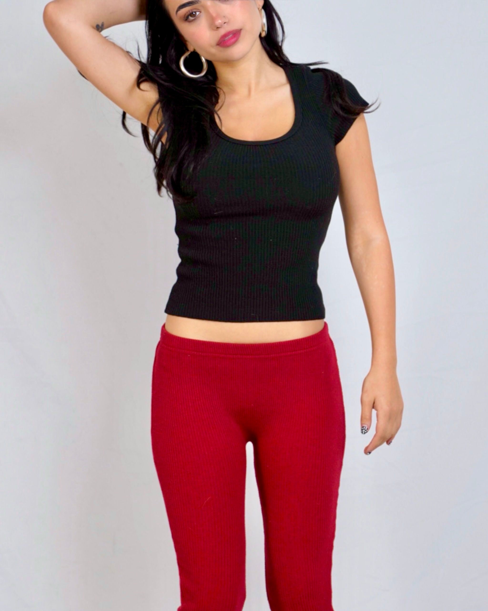 Woman wearing black scoop neck short sleeve rib knit top & red Capri by The Knit House LA. 