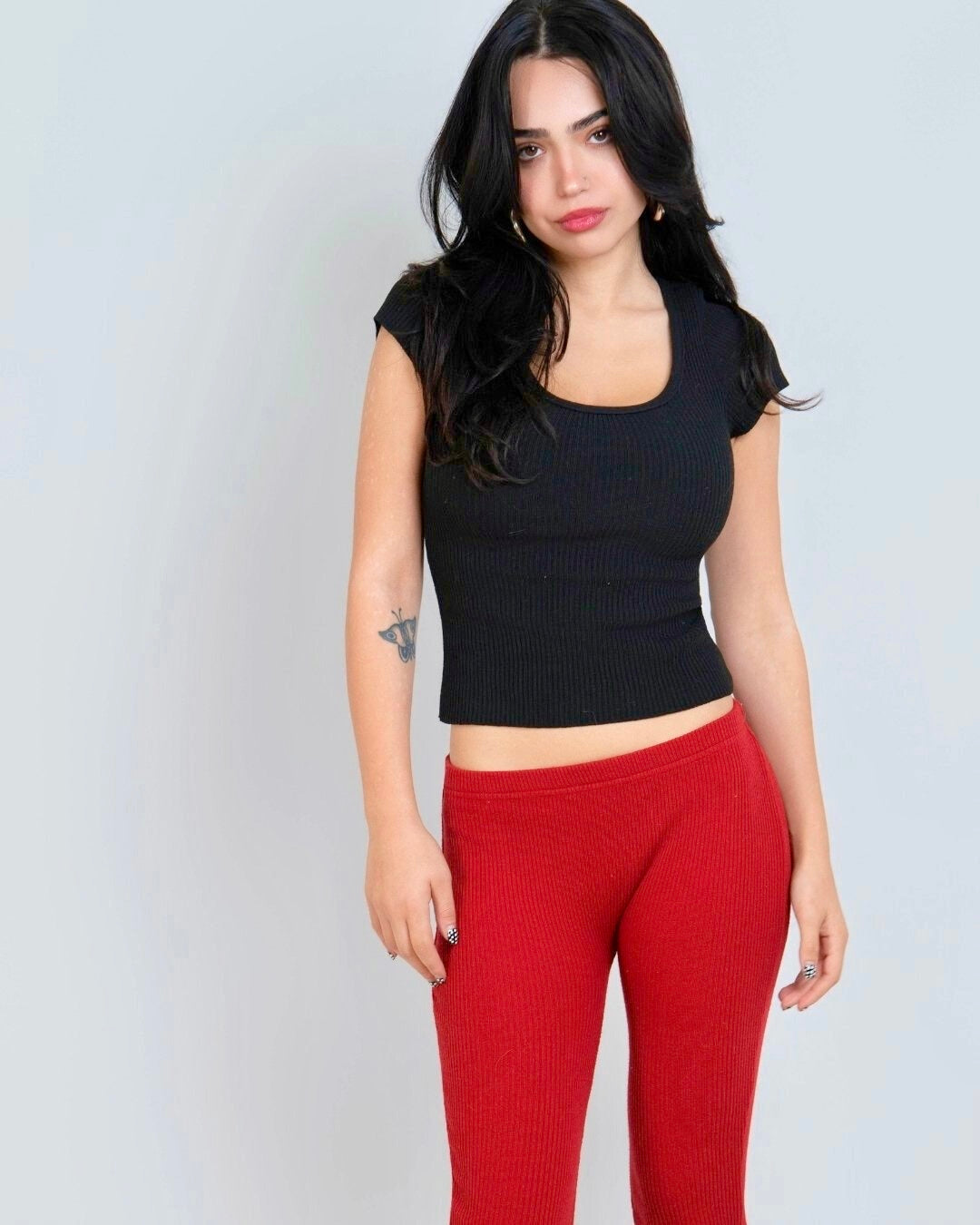 Woman wearing black scoop neck short sleeve rib knit top & red Capri by The Knit House LA. 