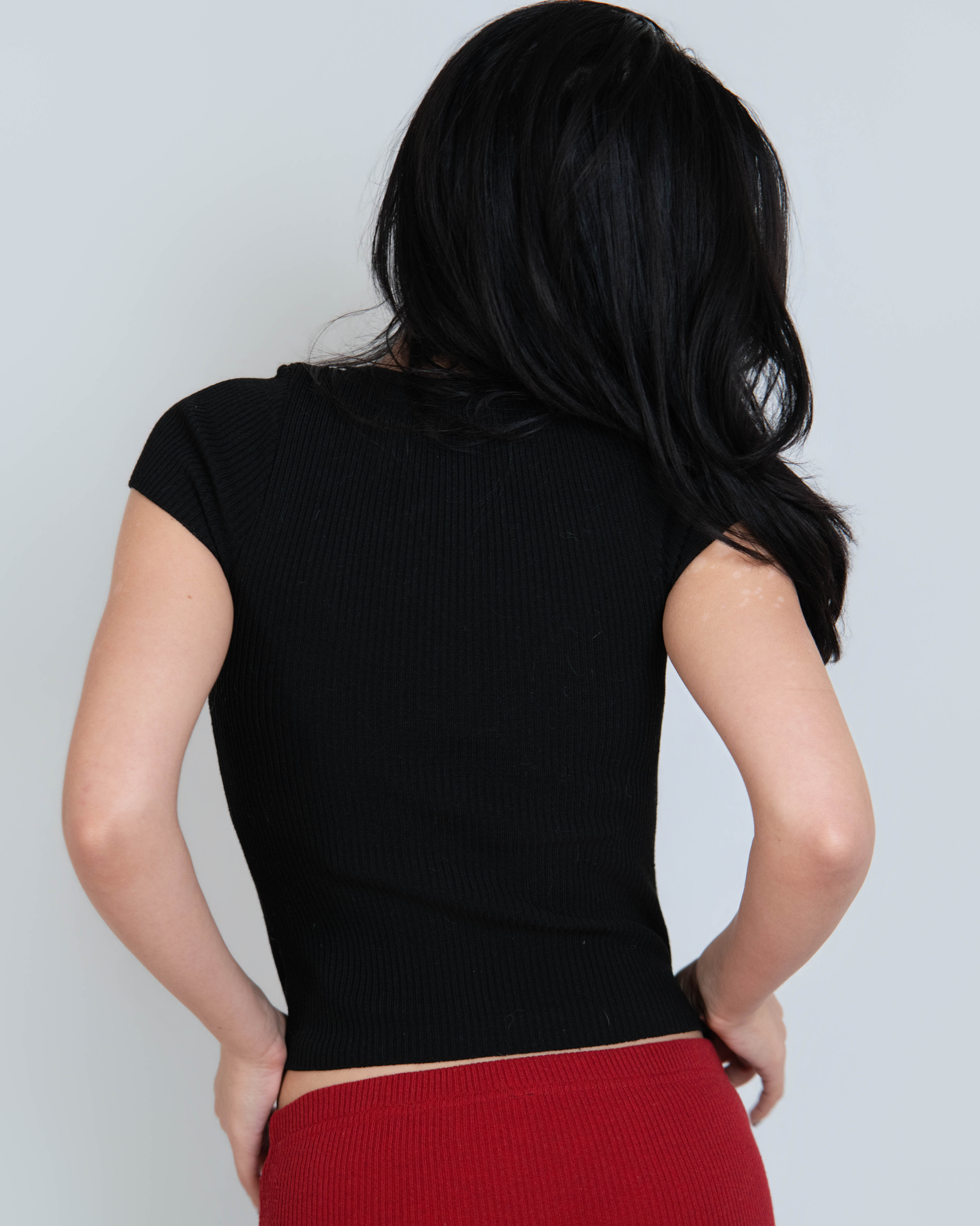 Back view of black short sleeve rib knit top & red pant by The Knit House LA