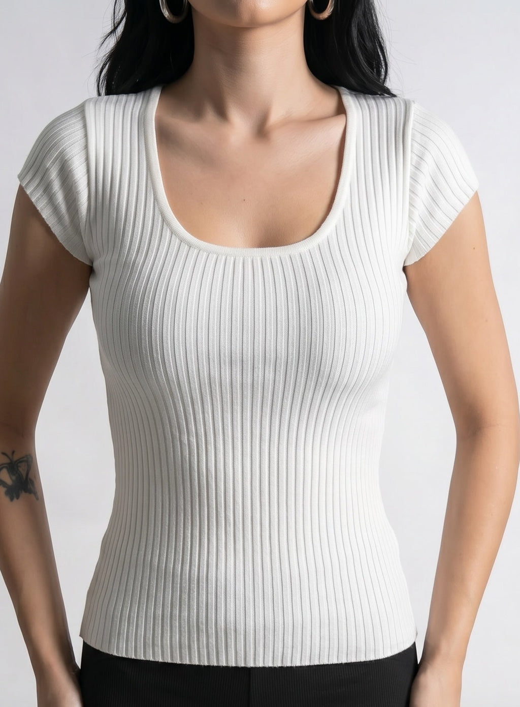 Close up of person wearing short sleeve white rib knit scoop neck top by TKHLA 