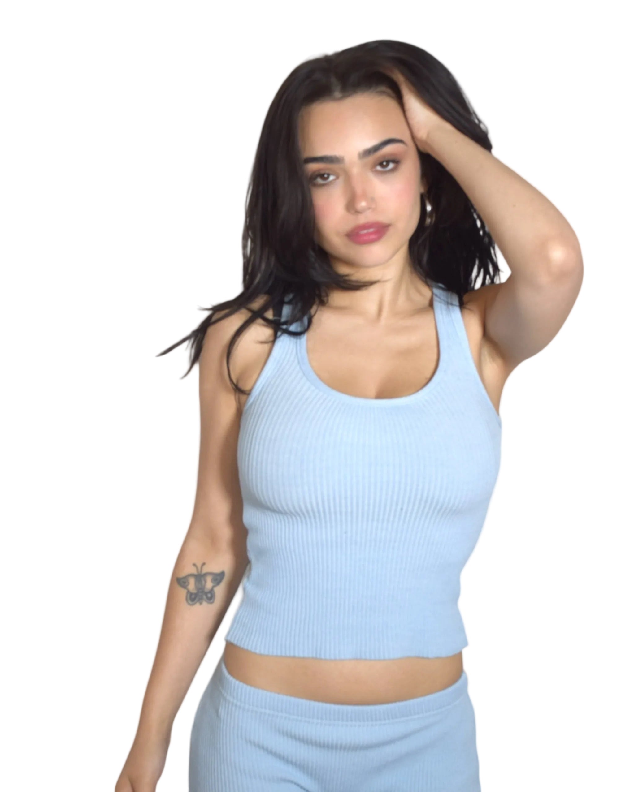 Woman wearing a light blue ribbed tank top against a plain background