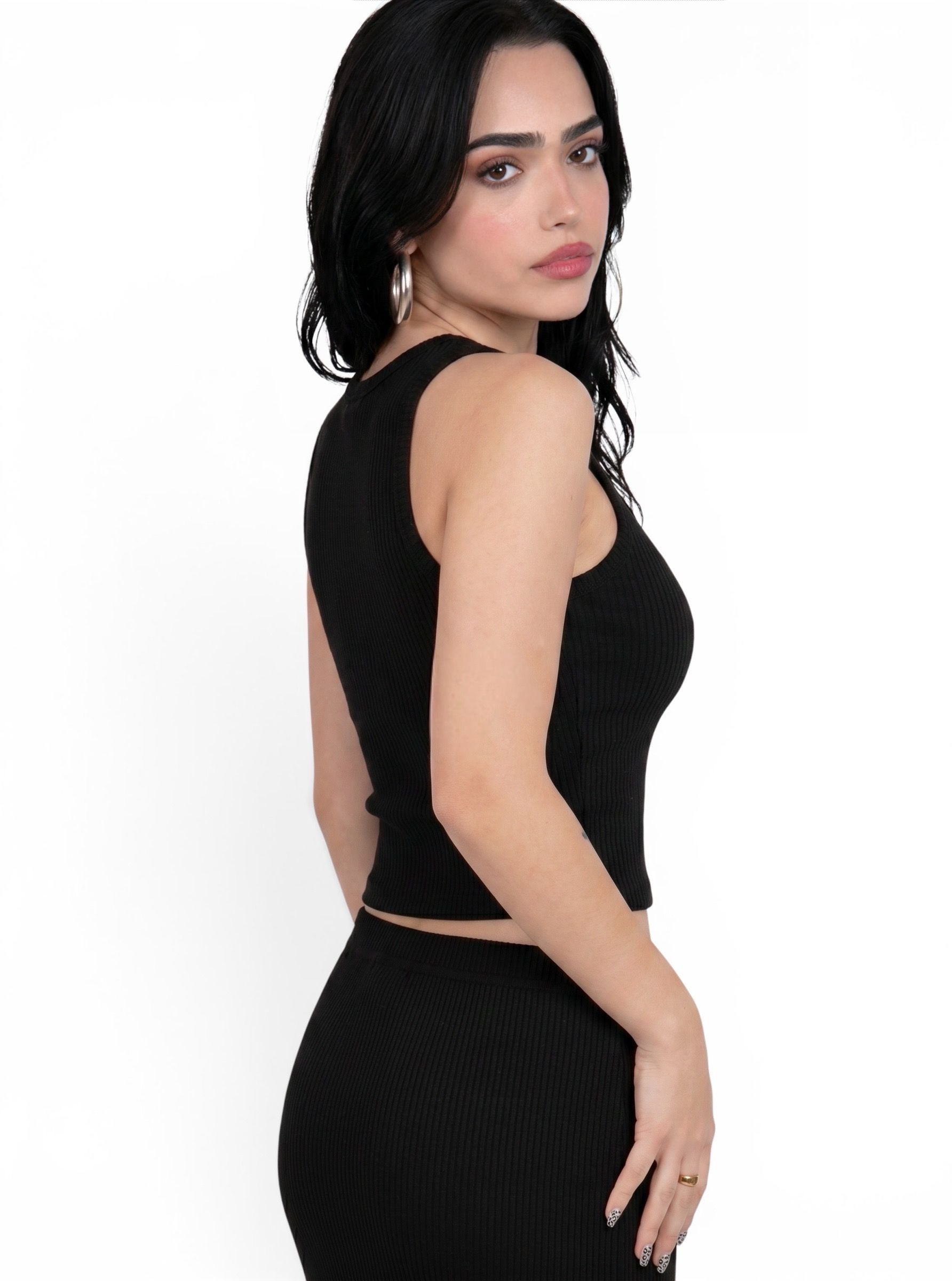 Woman wearing matching black rib knit tank and pencil skirt by TKHLA 