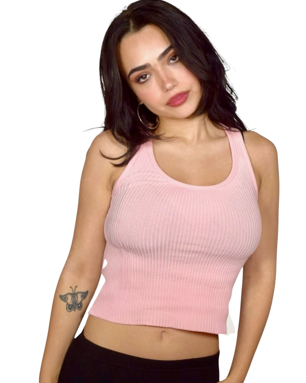 Woman wearing a pink ribbed tank top against a white background