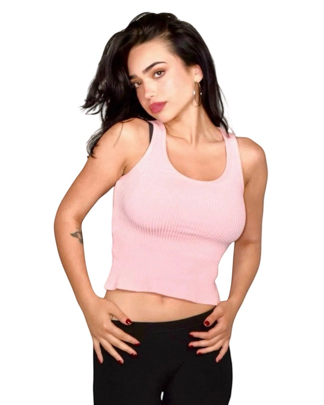 Woman wearing a pink crop top and black pants on a light beige background