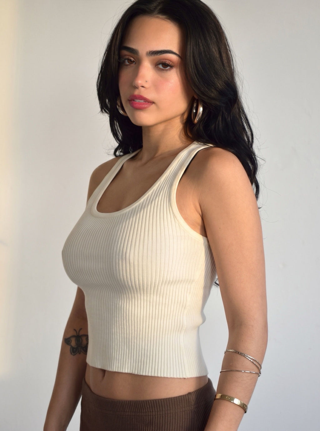 Woman wearing rib knit white scoop neck tank by TKHLA 