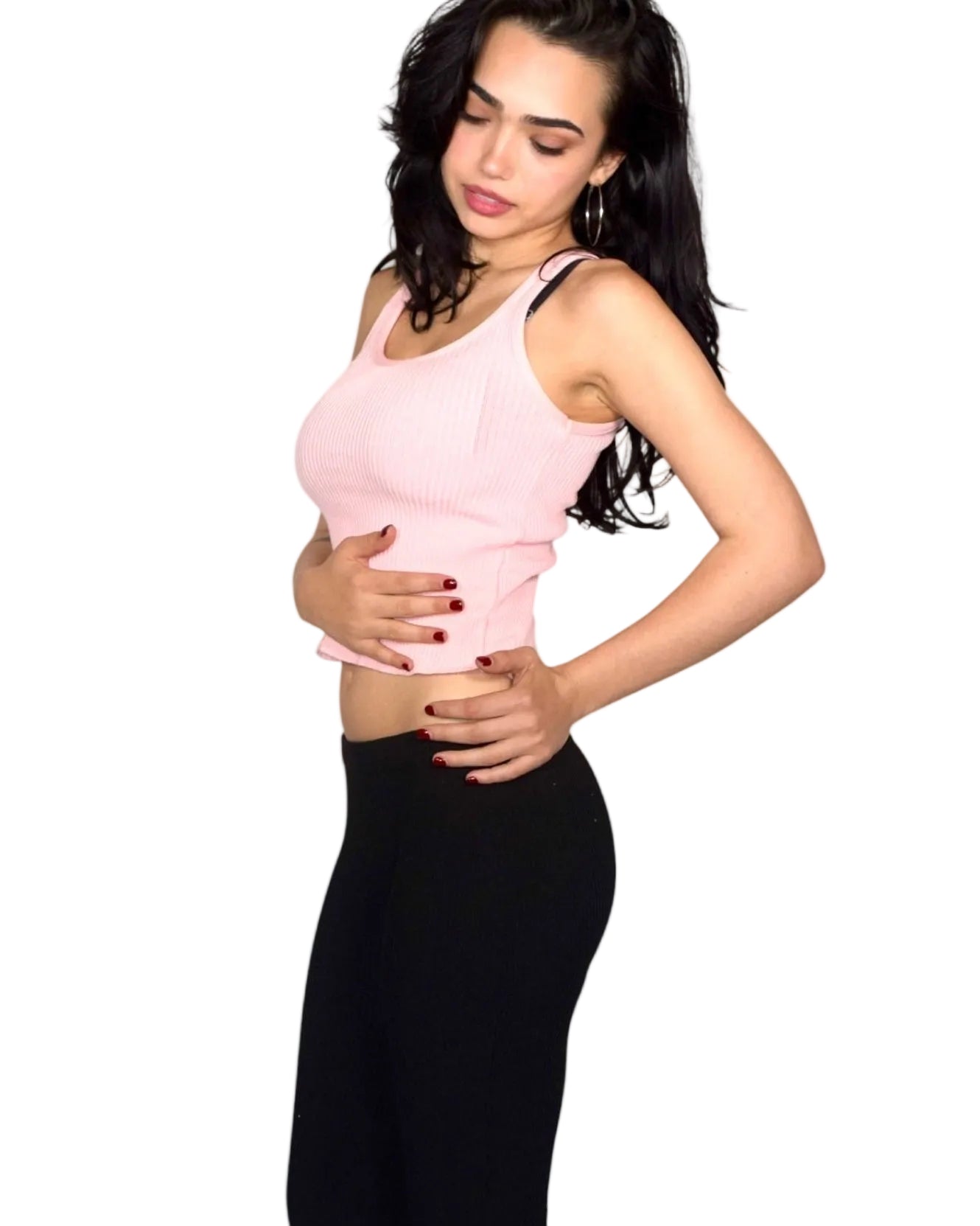 Woman wearing a pink top and black capri pants on a white background