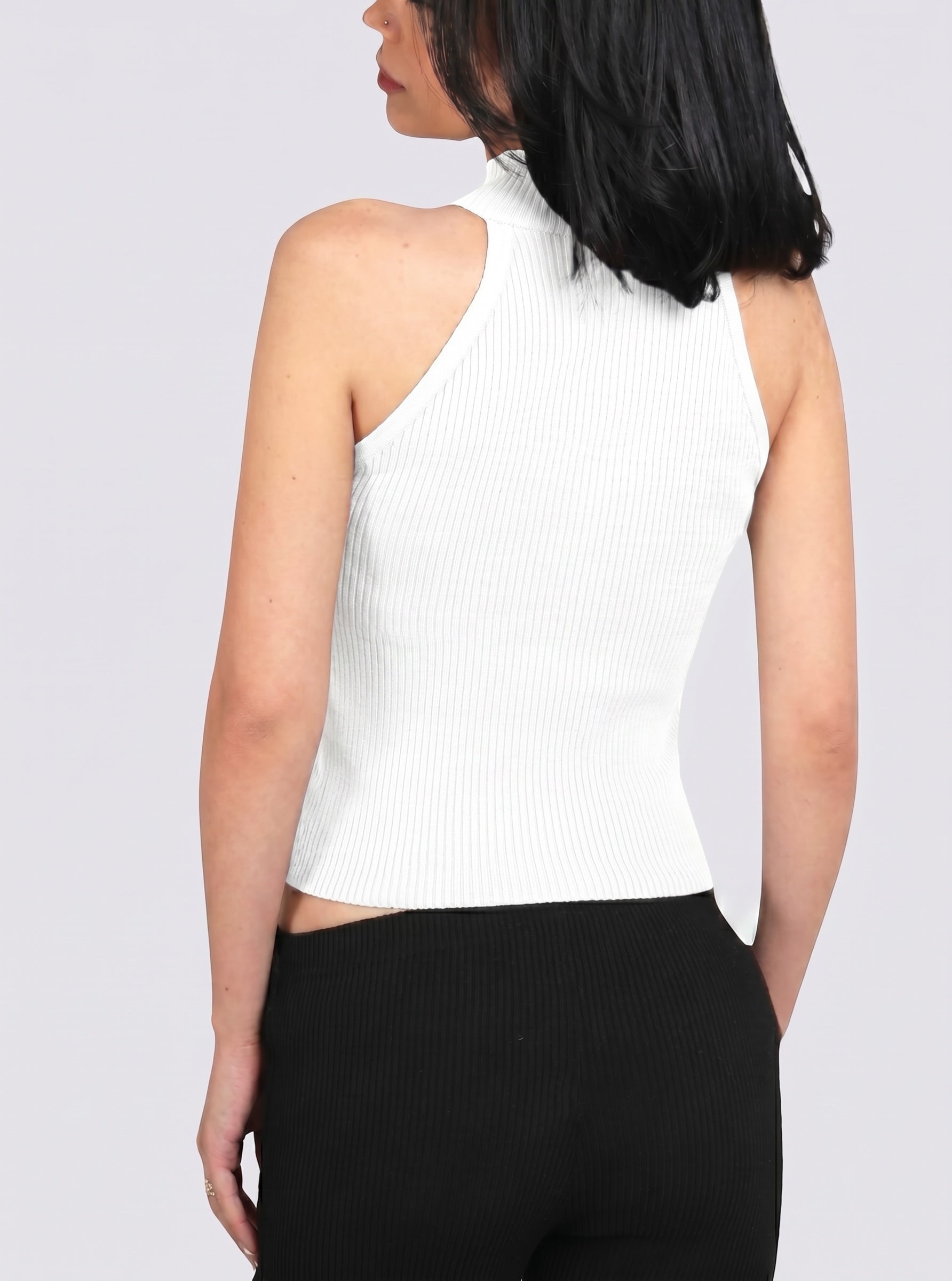 Woman wearing white rib knit mock neck shell with black Capri by TKHLA 