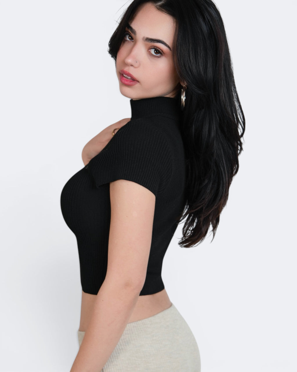 Woman wearing a black turtleneck top on a white background