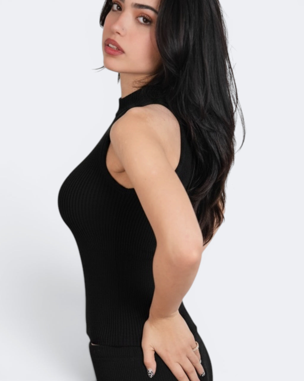 Woman wearing a black sleeveless top against a white background