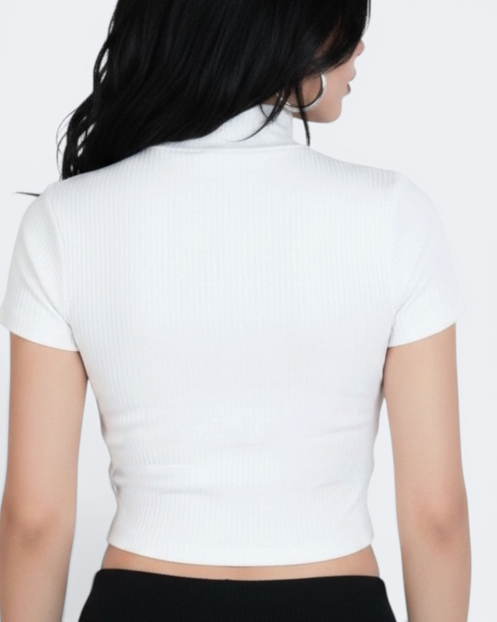 Person wearing a white cropped top on a plain background