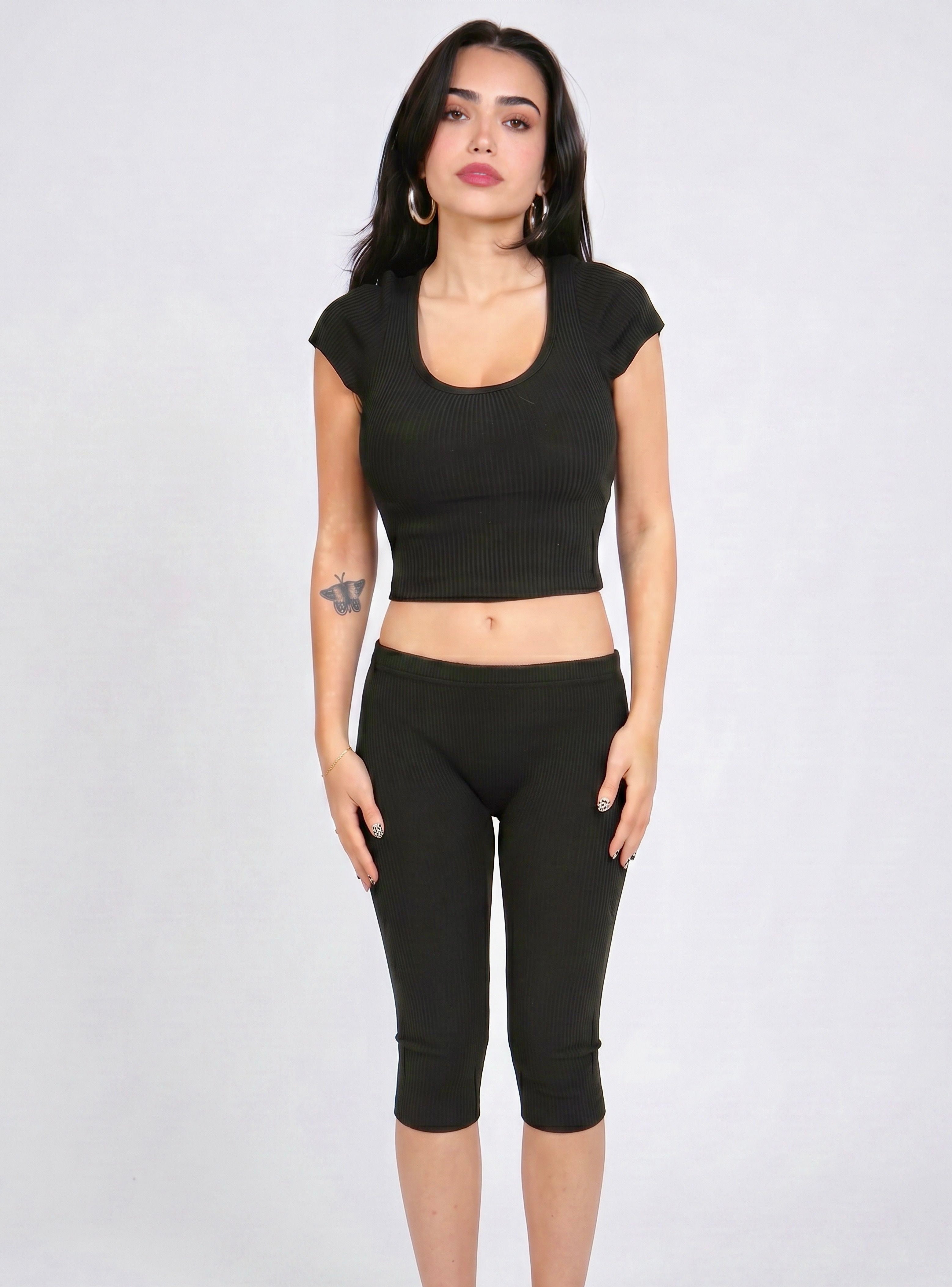 Woman wearing matching black rib knit crop scoop neck top and capri pants by TKHLA 