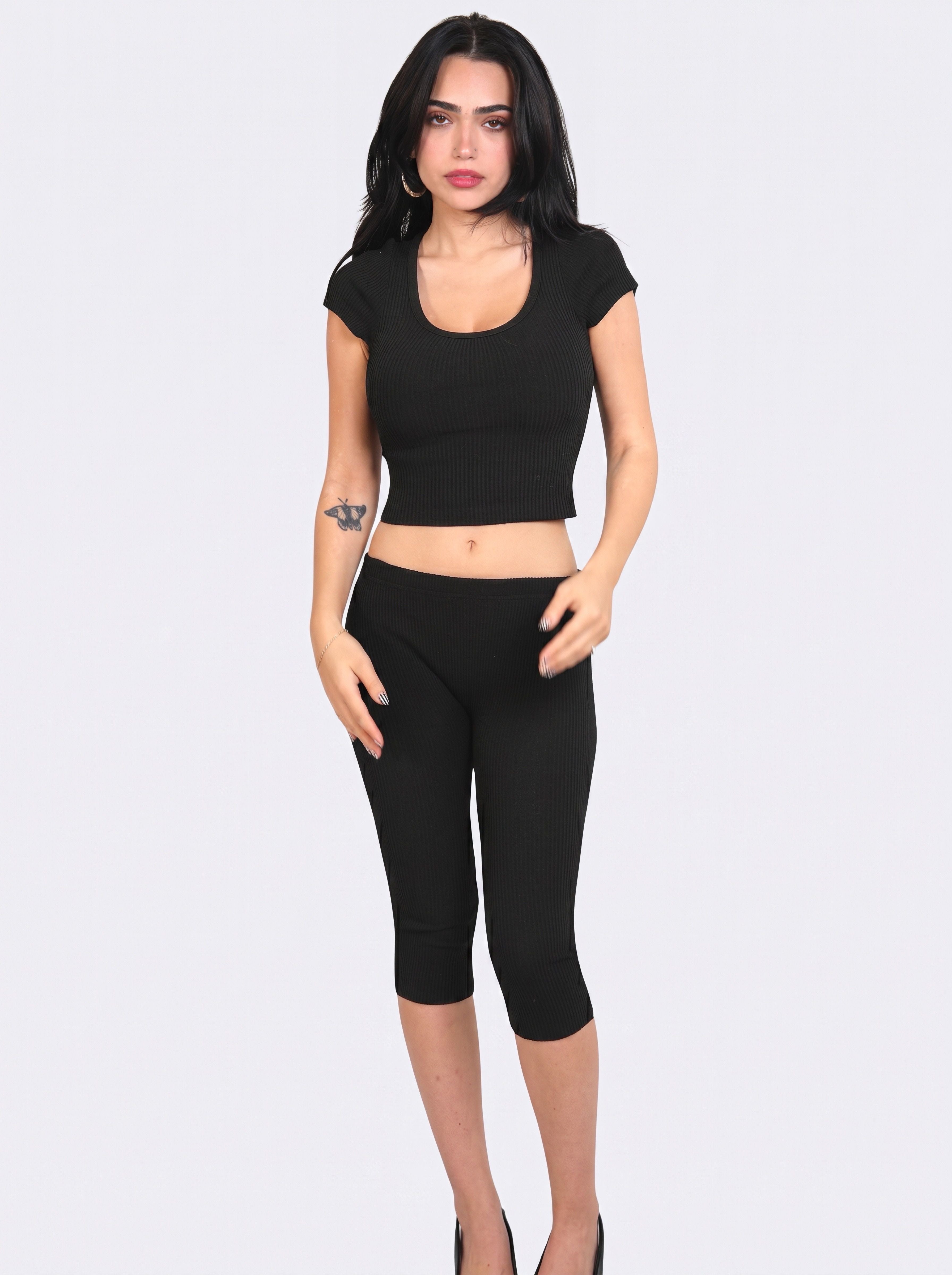 Woman wearing matching black rib knit crop scoop neck top and Capris by TKHLA 